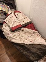 Comforter with floral embroidery and two matching pillow shams laid out on chair