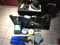 View of lot items including monitor lying flat, desktop tower, keyboard box, and various accessories scattered; shows overall lot condition and included items