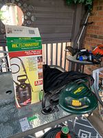 RL Flomaster sprayer box with sprayer and Yardworks blower/vac on glass table.