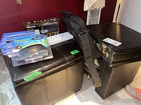 Overview of all items in lot including storage ottoman, boxed staplers, briefcases, and laptop bag.