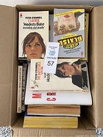 Top view showing multiple Peter O'Donnell books featuring the character Modesty Blaise including 'I Lucifer' and 'The Impossible Virgin'