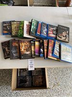 Photo showing a spread of DVD and BluRay cases laid out on table, various movie titles visible.