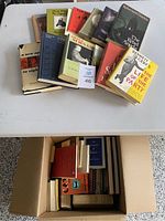 Overview of assorted older books laid out on a flat surface, showing various titles and covers.