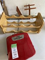 Photo of red George Foreman grill in front of two wooden wine holders with three rows