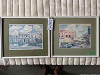 Two framed prints side by side on a beige surface, showing the artwork of Barbados scenes by Jill Walker.