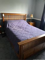 Full view of assembled king size bed frame with quilted bedspread