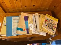 Top view of worn sheet music and music books spread over a wooden cabinet