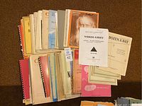 Top view of various piano books and sheet music arranged overlapping on a flat surface, showing condition and variety of items in the lot.