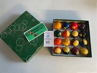 Full set of 16 pool balls in original green box with label 'Belgian Aramith Balls'.