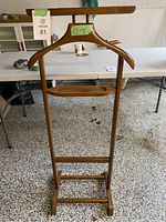 Full view of the vintage wooden valet stand showing the jacket hanger, tray, and base.