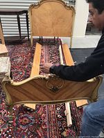 Headboard, footboard and one side rail laid on patterned rug