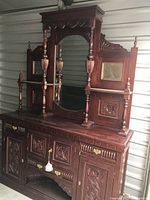 Full view of two-piece mahogany buffet showing detailed carvings and large oval mirror