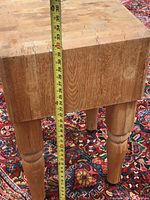 Photo of butcher block island with measuring tape from floor to top showing approximately 33 inches height.