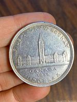 Reverse side of 1939 Canadian Silver Dollar coin showing Canadian Parliament buildings and inscriptions.