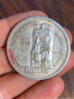 Front side of the coin featuring the totem pole and mountain design, inscriptions CANADA, 1858-1958, BRITISH COLUMBIA, DOLLAR.
