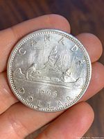 Reverse side of the 1966 Canadian silver dollar showing the Voyageur design in a canoe with the year 1966.