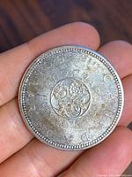 Reverse side of the 1967 Canadian silver dollar coin showing the floral design with surrounding text.