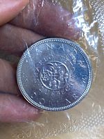 Reverse side of the coin featuring 1967 Confederation floral design and inscriptions.