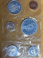 Photo of six 1966 Canadian coins in original plastic packaging from the front, varying sizes and denominations