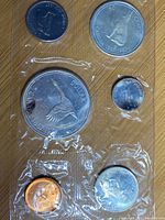 Top view of first 1967 Canadian uncirculated coin set with 6 coins including 1 dollar featuring goose, 50 cents with Canadian shield, others.