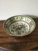 Full view of hand painted porcelain bowl showing detailed exterior and interior designs.