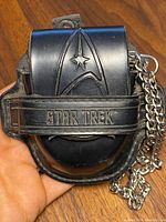 Front of black leather carrying case with embossed Star Trek insignia and logo.