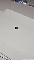 Pear shaped blue green sapphire gemstone on white background, showing top and slightly angled side views