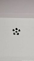 Six heart-shaped green sapphires arranged on a white background showing size and shape consistency.