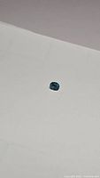 Loose oval cut natural Cambodian blue zircon gemstone approximately 5.8x5 mm, 1.46 carats shown on white background.