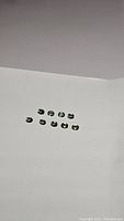 Ten small oval mint green gemstones displayed on white background, arranged in two rows.
