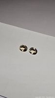 Pair of oval cut golden citrine gemstones on a white background, showing facets and clarity.