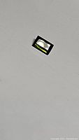 Rectangular baguette cut green tourmaline gemstone on white background showing color and cut