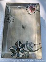 Rectangular platter with gray background and hand painted flowers in blue, pink, and green hues.
