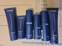 Six items including three Curology cleanser tubes and three moisturizer bottles arranged on a cardboard surface.