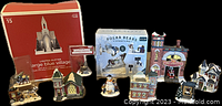 Photo showing the full assortment of Christmas village pieces including boxed church, fire station, houses, polar bears and other figurines.