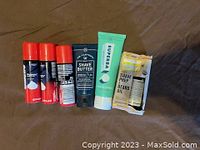 Six grooming items including three Edge shave cream travel cans, DR Carver's shave butter, Superba toothpaste, and shave prep & beard oil in box.