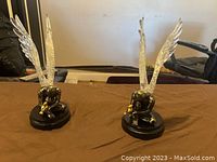 Pair of angel wing sculptures on a brown surface showing both sculptures and their details