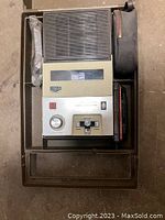 Top view showing the cassette player inside the carrying case, control panel with volume knob, cassette control switches, and speaker grille.