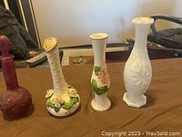 Four vintage vases arranged in a row, showing different shapes, colors, and designs.