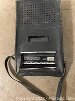 Photo showing the back of the carrying case with speaker perforations and integrated circuit auto level control label.