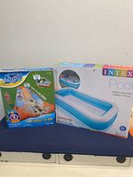 Photo showing the boxed 10-foot Intex inflatable pool and boxed 18-foot Big Toy triple water slide side by side.