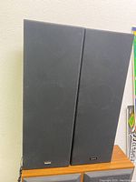 Two Sanyo tower speakers standing side by side with black fabric fronts and visible Sanyo logo at bottom.