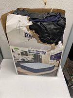 Photo of folded dark blue and white patterned Queen size air mattress inside torn Bestway box with product images showing 20 inch height and room setting illustrations