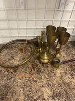 Group photo showing large horn, smaller horns, four goblets, miniature teapot and pitcher on brown countertop