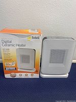 Photo of Soleil digital ceramic heater alongside the original product box showing product name and safety features.