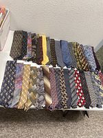 35 assorted silk neckties arranged flat showing variety of colors and patterns.