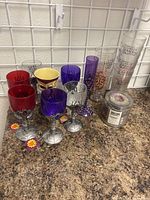 Lot of multiple Halloween-themed cups showing varied colors and designs on countertop.