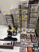 Wide shot showing tall stacks of game cases and cartridges on a table