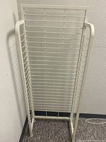 White metal wire shelving unit with grid design, photographed from front and angled side.