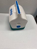 Side view of white and teal Mini Mate Igloo Cooler with handle and brand label